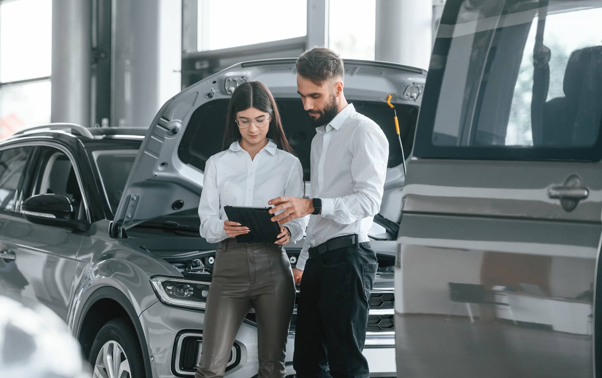 People in front of car at dealership