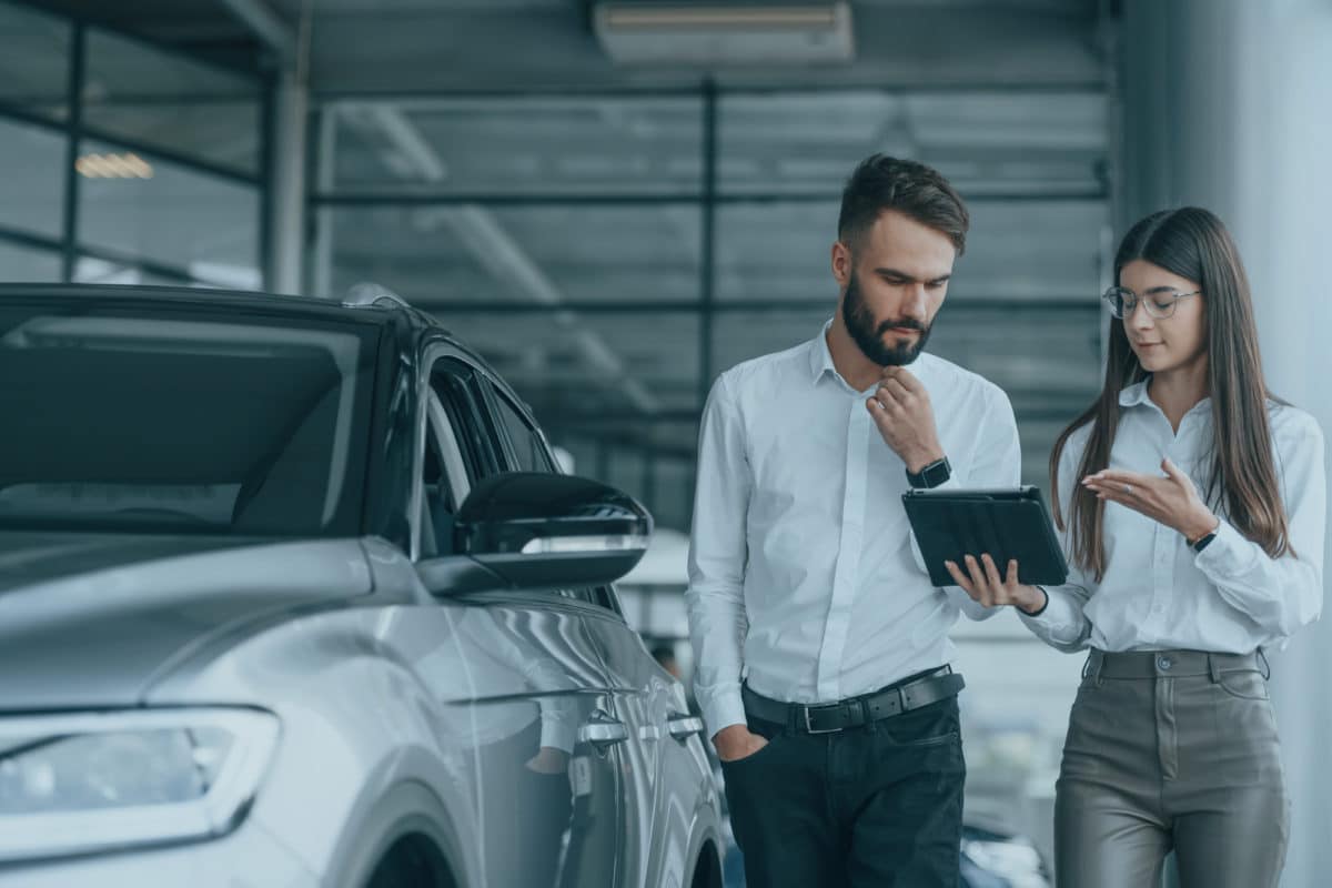 Two people at a dealership