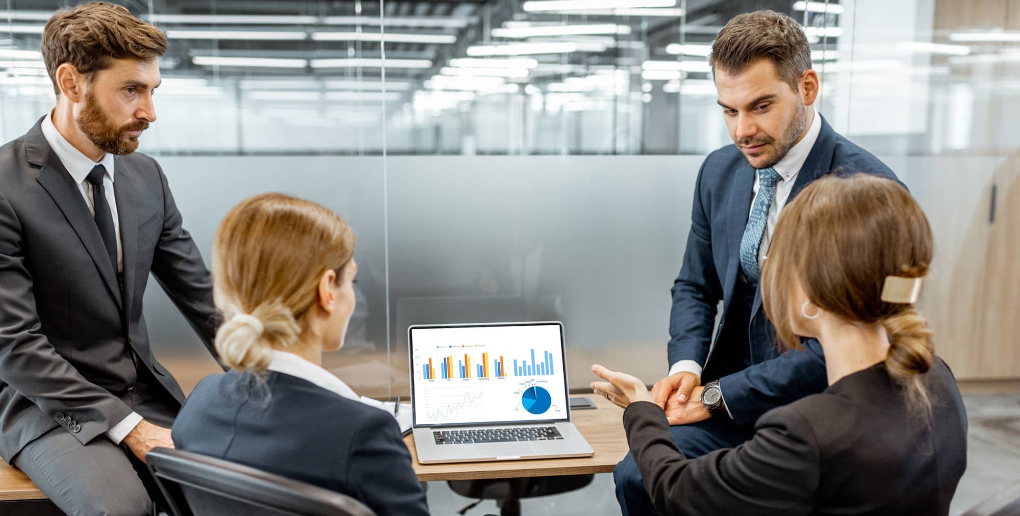 People talking at desk with laptop